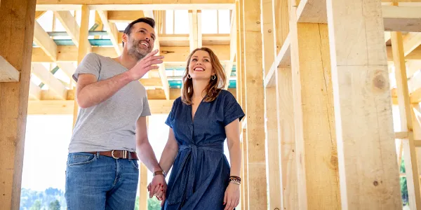 Couple walking in house under construction