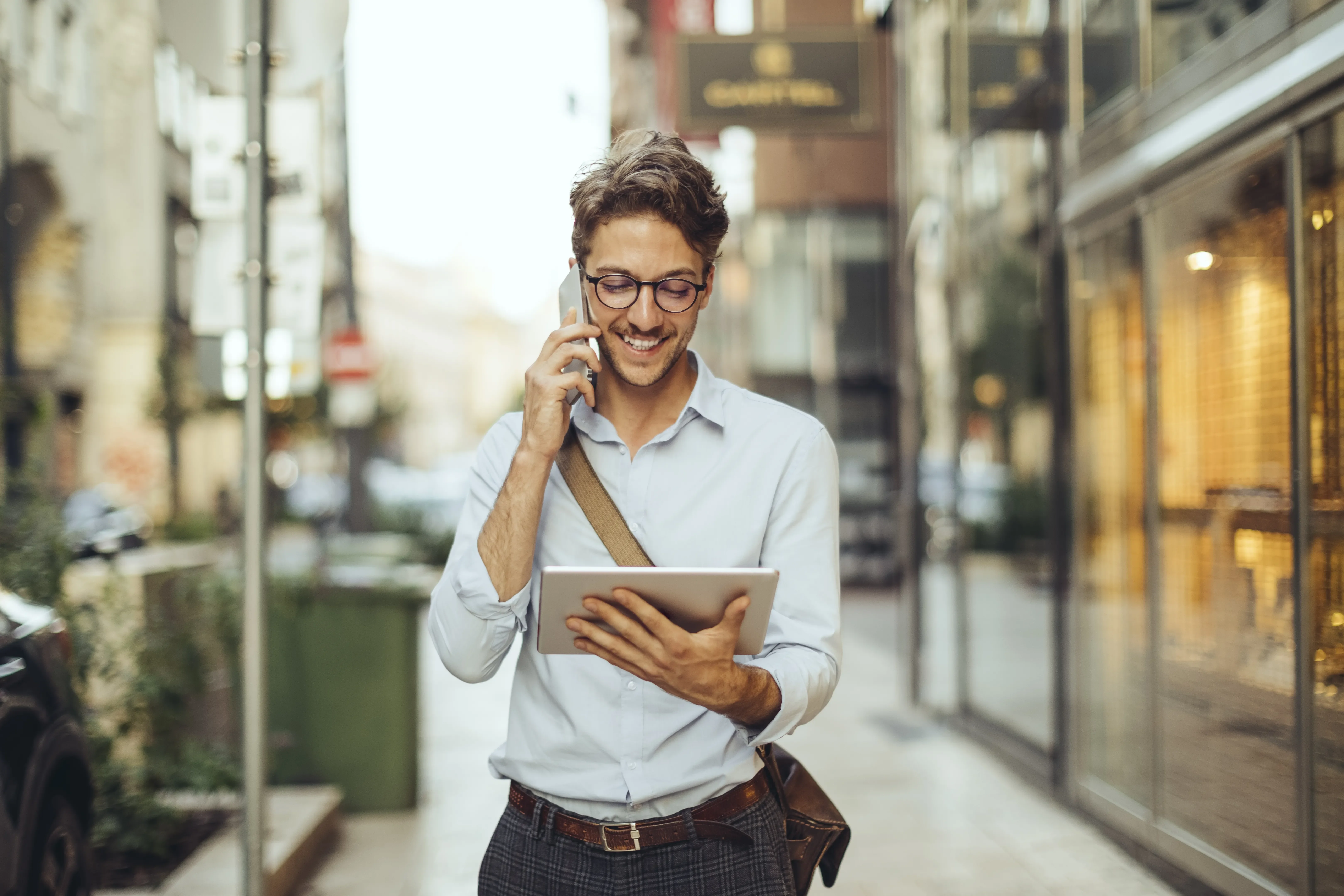 Businessman walking down the street taking a phone call